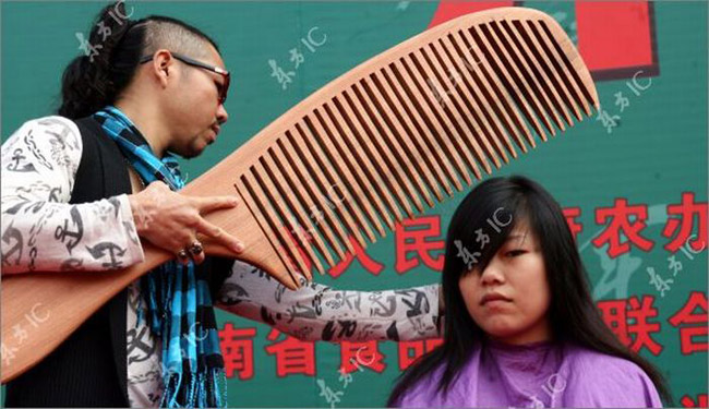 Một nhà tạo mẫu tóc người Trung Quốc sử dụng chiếc lược khổng lồ và cây kéo, tất cả đều dài 1,3 mét.
